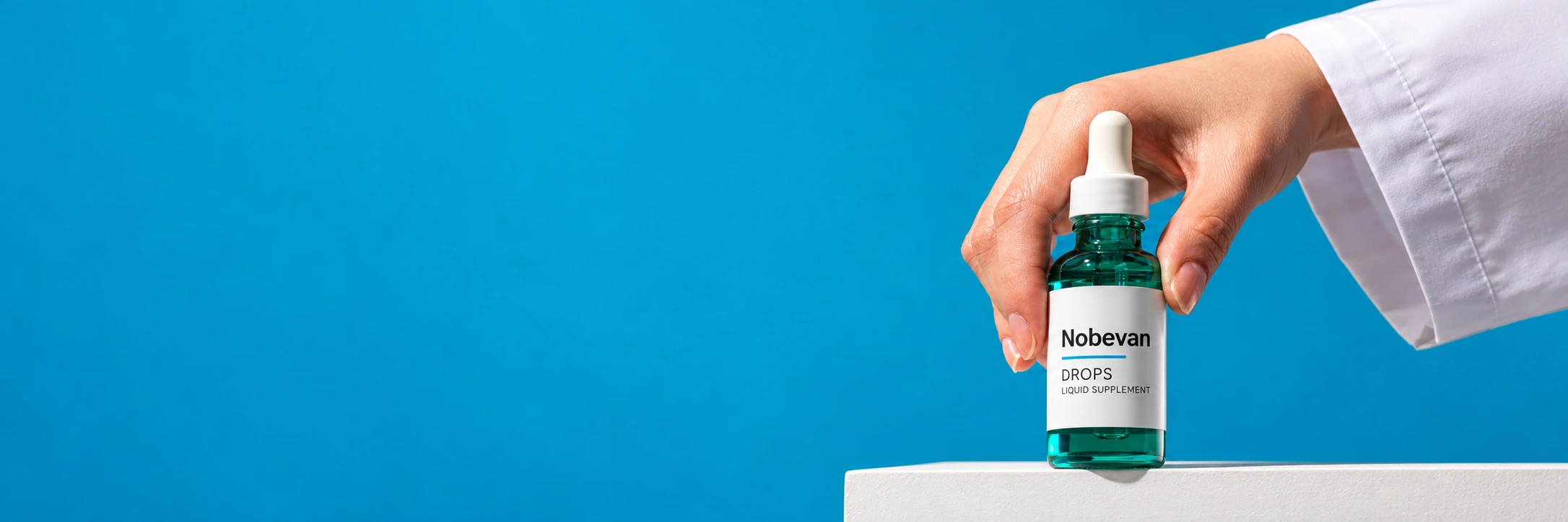 A hand holding a green Nobevan drops bottle on a blue background