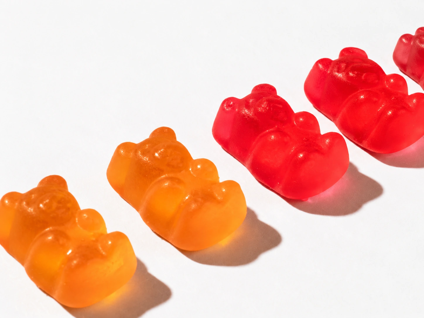 Red and orange translucent gummy bears on a light background